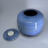 Small ceramic memorial urn with removable candle holder lid in soft blue glaze