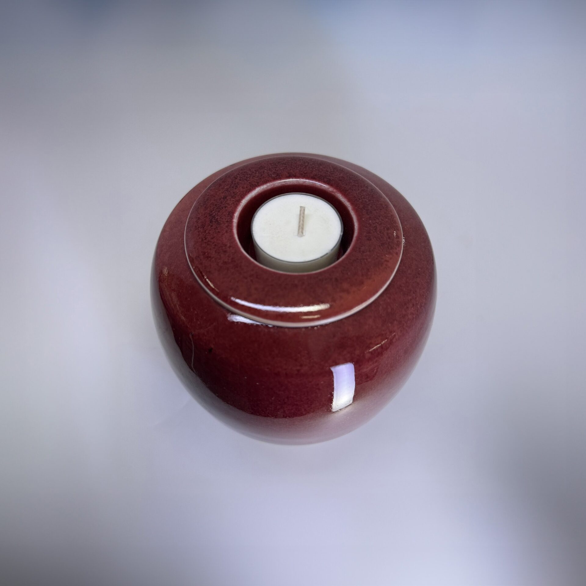 Ember 900ml cremation urn top view showing tealight candle holder and rich red glaze