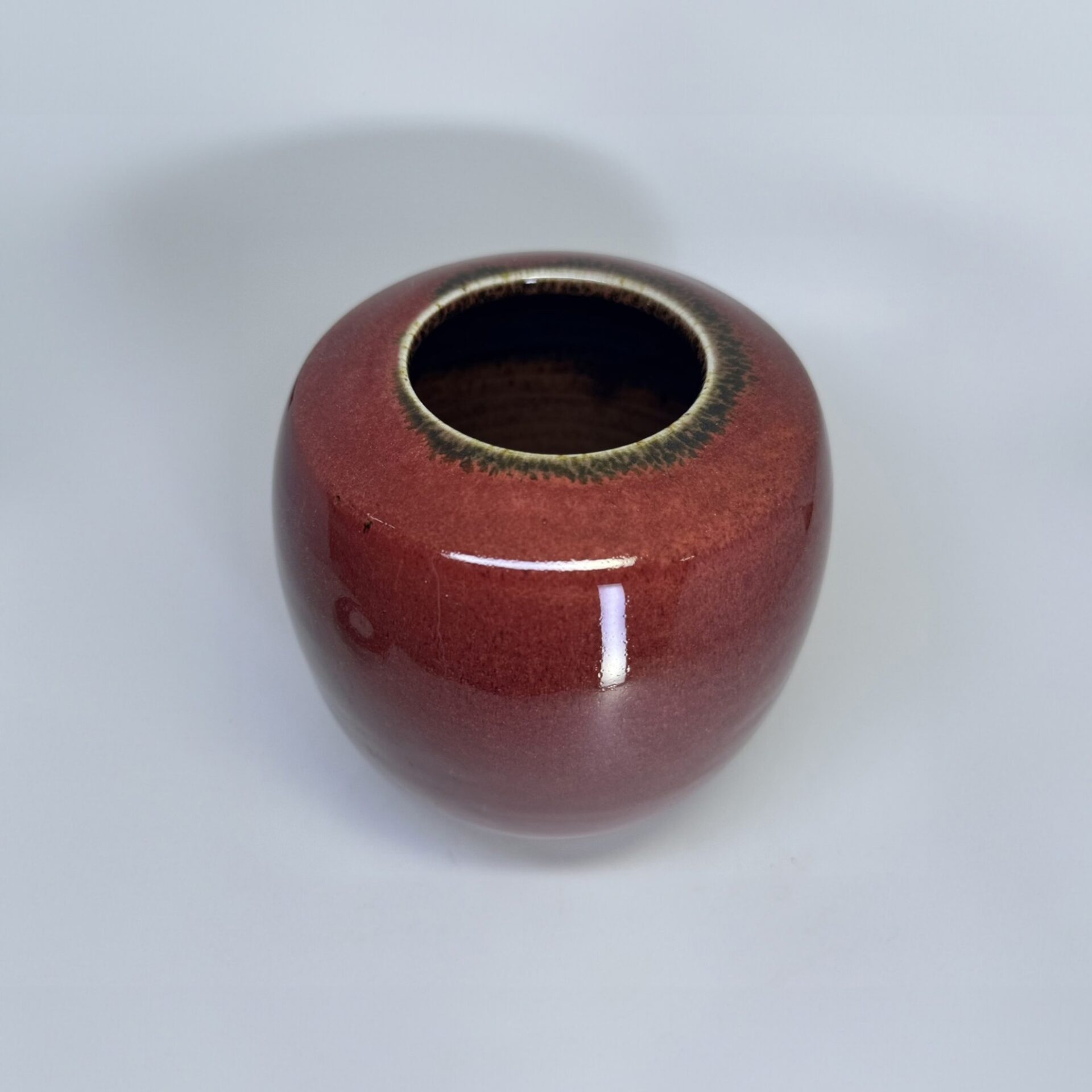 Ember cremation vessel without lid showing opening and warm terracotta red finish