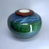 Ceramic cremation vessel with nature-inspired green and blue layered glaze and tealight holder
