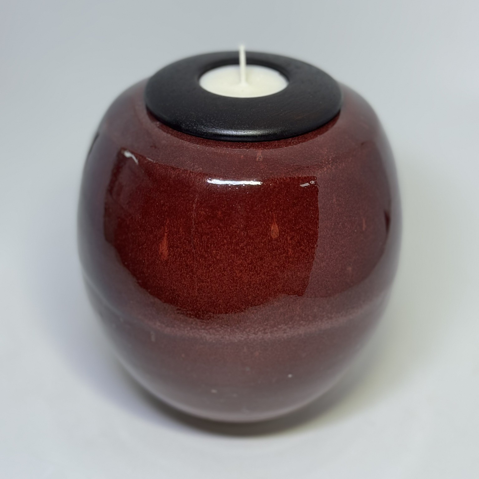 Flame ceramic cremation urn with deep red burgundy glaze and black tealight candle holder