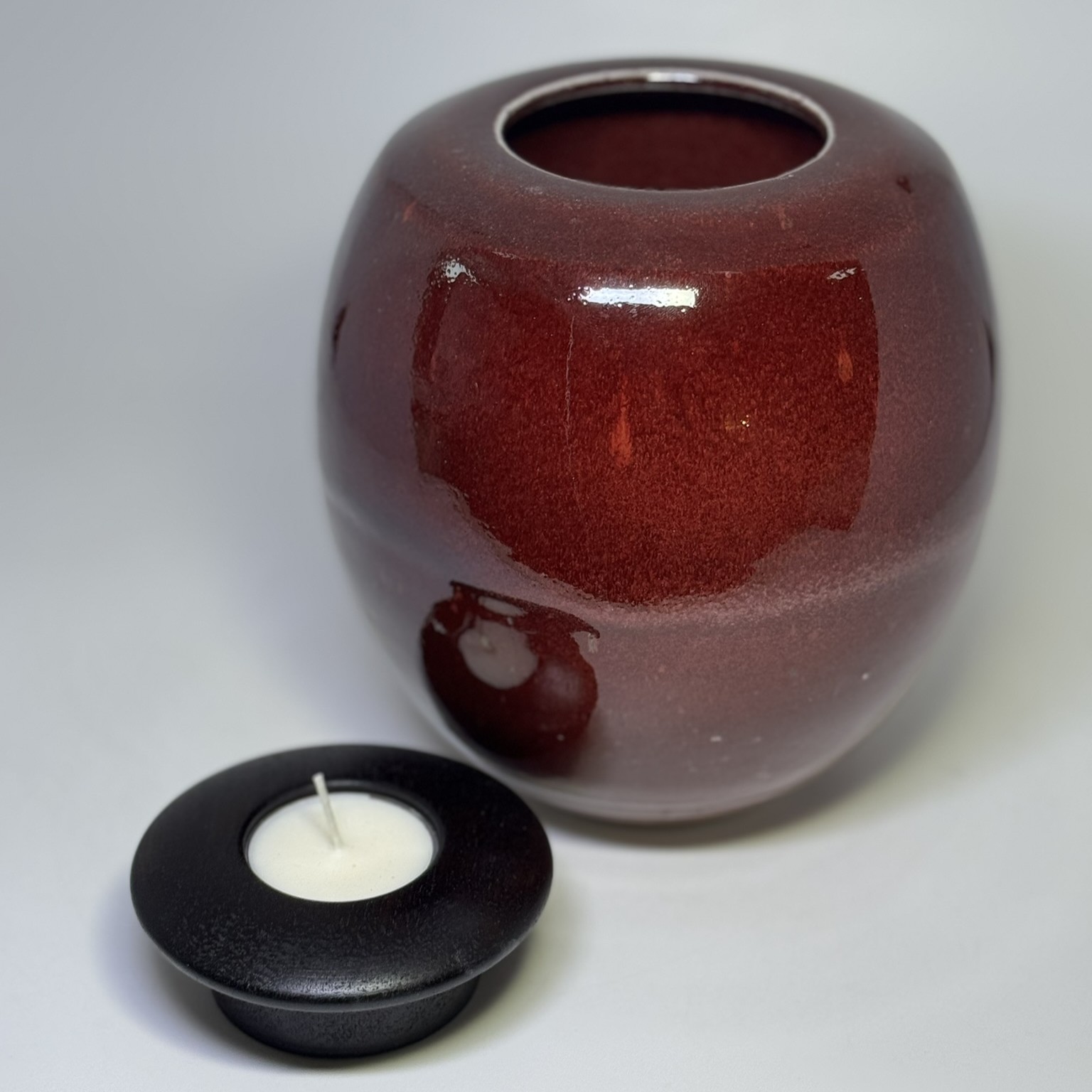 Medium ceramic memorial urn with removable black candle holder lid in flame red glaze