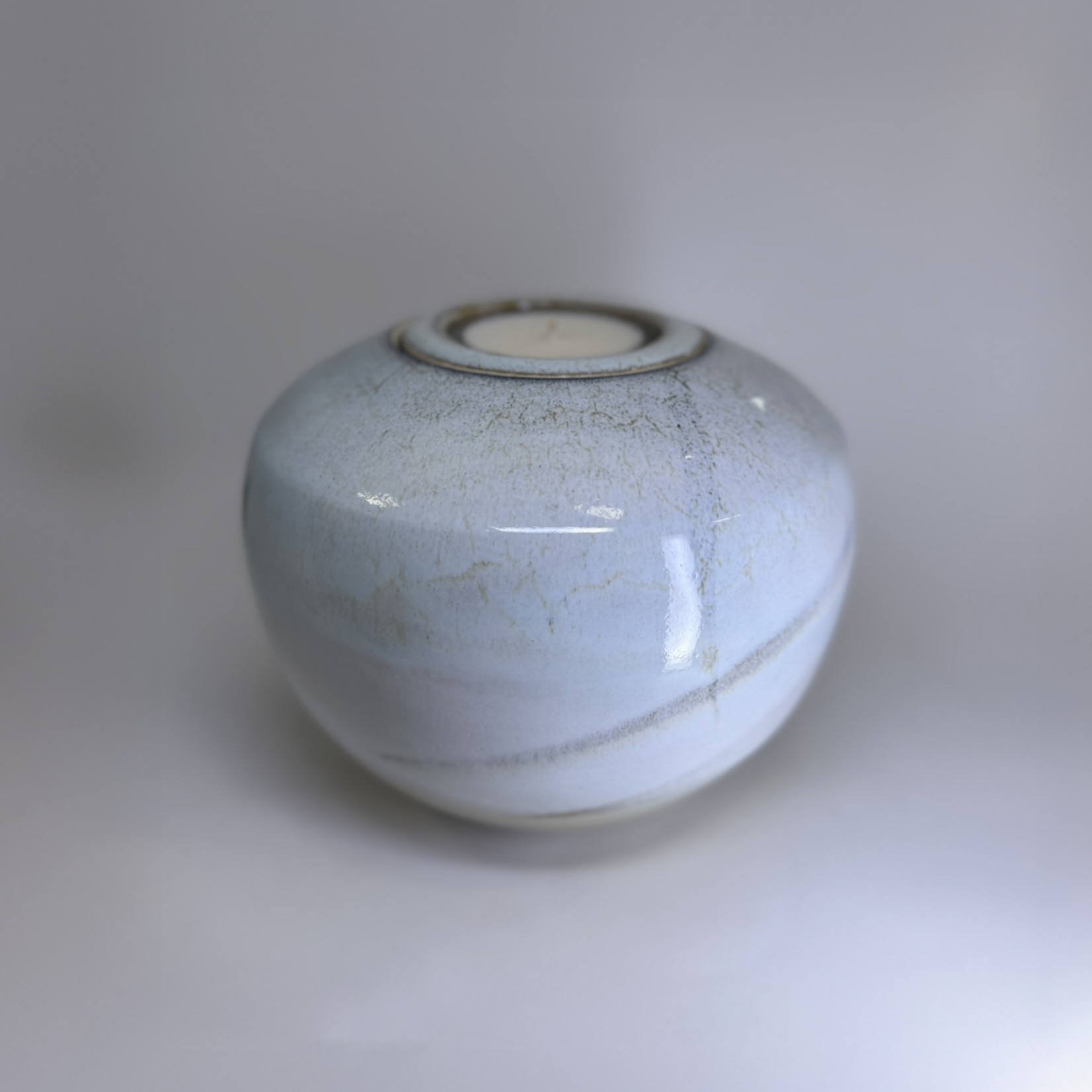 Ivory ceramic cremation urn with soft white speckled glaze and tealight candle holder
