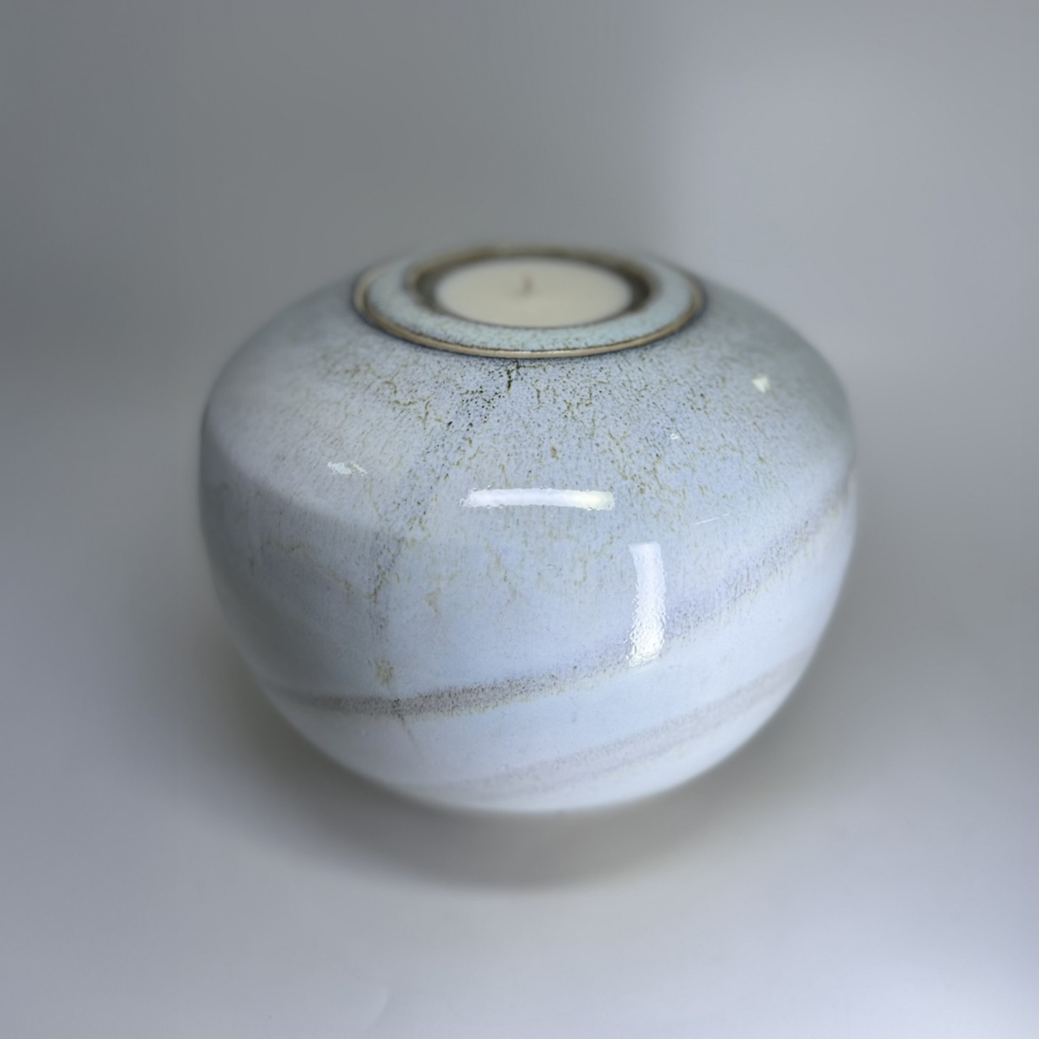 Ivory white ceramic cremation urn with natural glaze variations and glossy finish