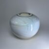 Ivory ceramic cremation vessel with integrated tealight holder and gentle speckled surface