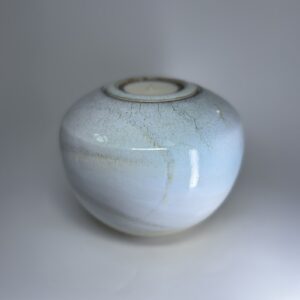 Ivory ceramic cremation vessel with integrated tealight holder and gentle speckled surface