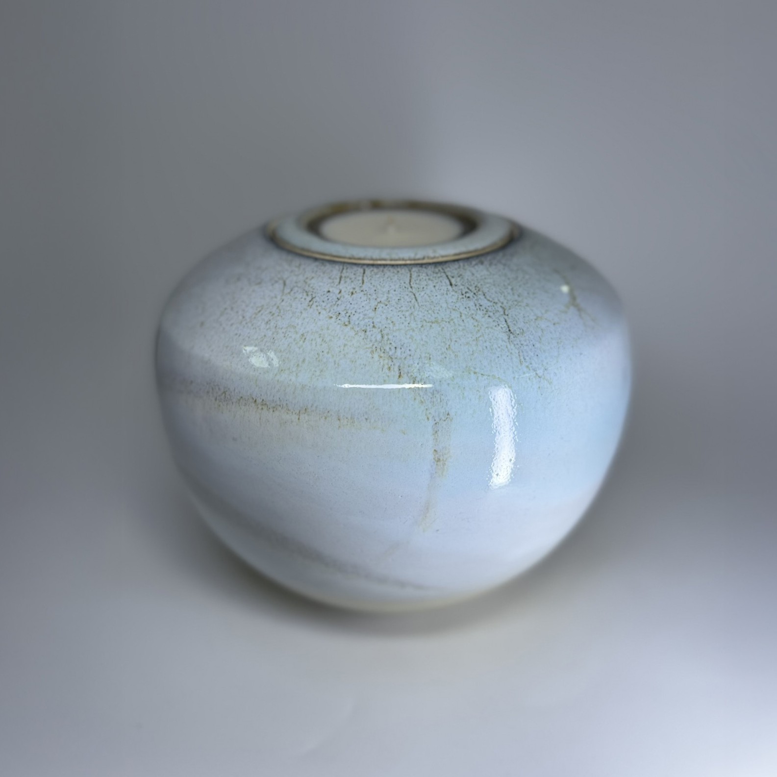 Ivory ceramic cremation vessel with integrated tealight holder and gentle speckled surface