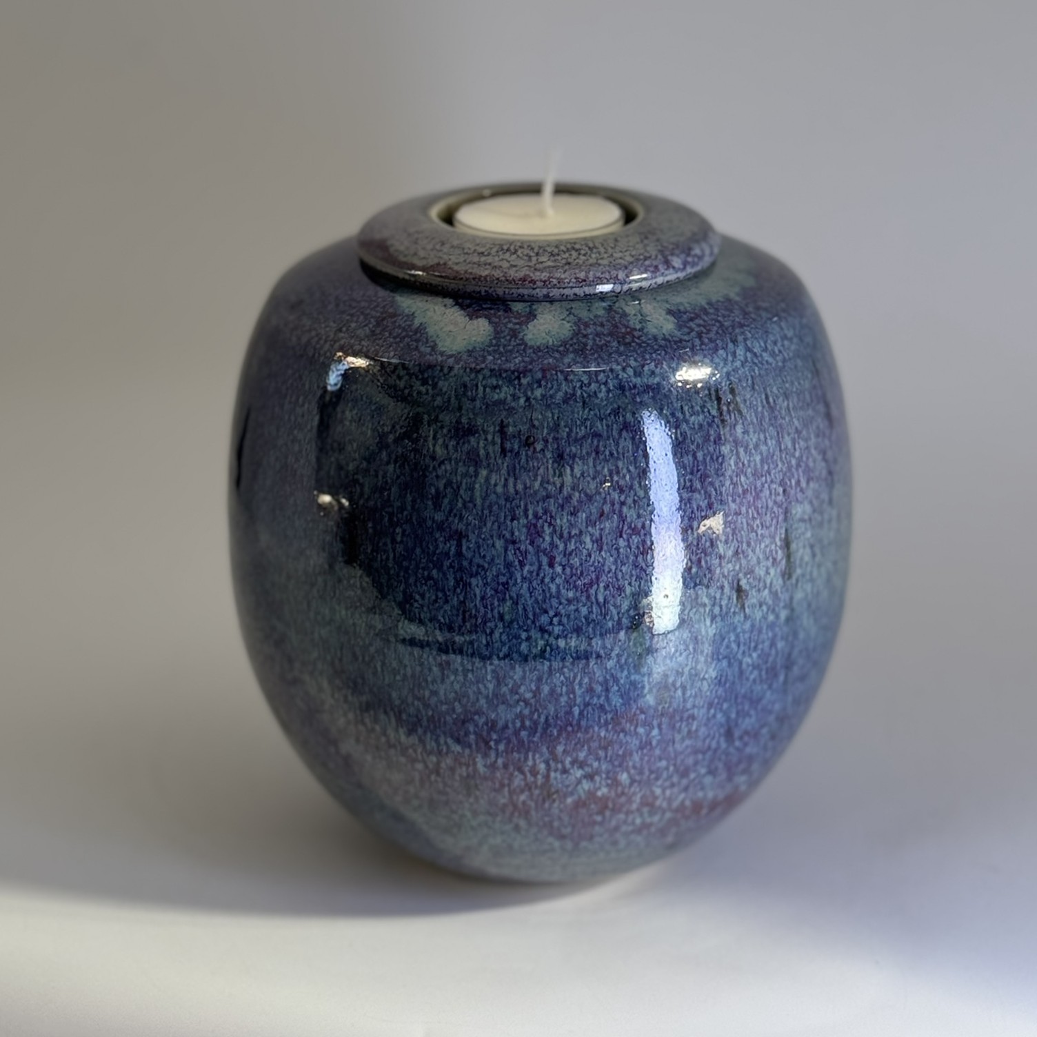 Purple Rain small ceramic cremation urn with deep purple and blue gradient glaze and tealight holder