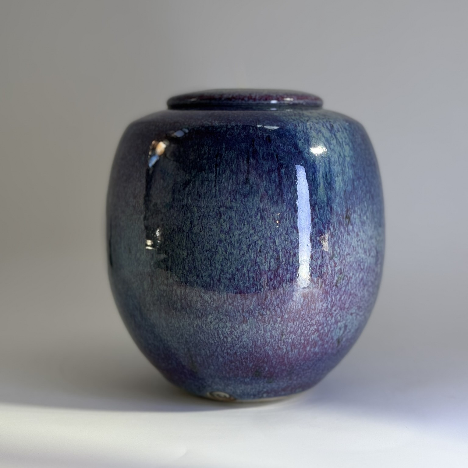 Small ceramic urn showing rich purple blue gradient with subtle pink undertones